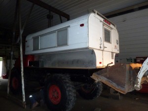 The tricky task of putting the camper and deck on the back of the Mog. We used a chain hoist and a bobcat